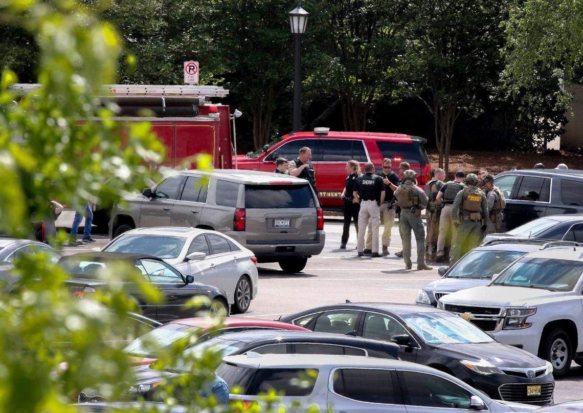 Law enforcement personnel stage on the back side of the Columbiana Centre mall in Columbia, S.C. on Saturday, April, 16, 2022. At least three individuals with guns were detained after a shooting incident that left 12 people hurt.