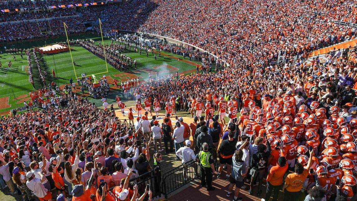 Clemson Tigers players run down the hill before a 2023 game against North Carolina