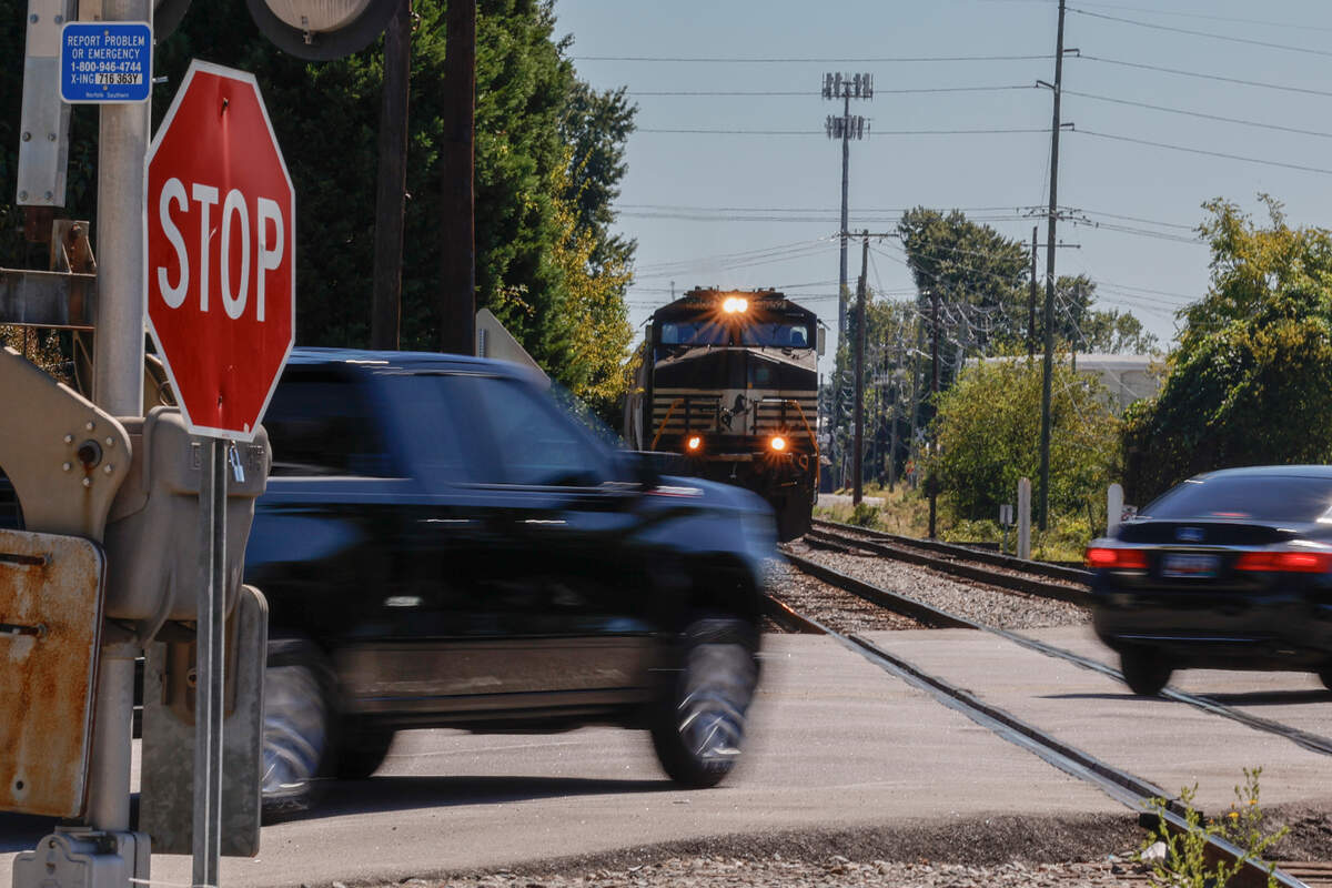 Motorists pass in front of a train before the crossing barricade is lowered at Assembly Street near Whaley Street at one of the 15 railroad crossings on the main Columbia thoroughfare.