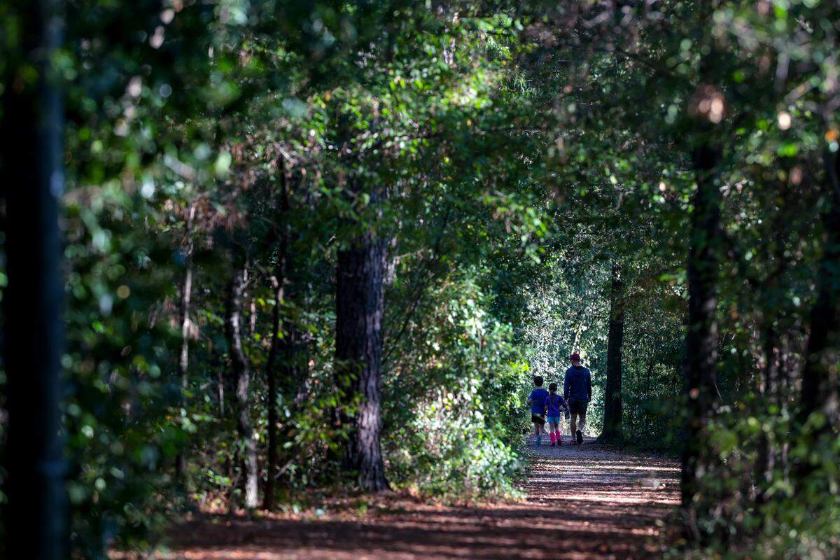 Tanner Arrington walks along the Rosewood Nature Trail with his children, Truman Arrington, 8, and Celia Arrington, 6. They regularly walk the trail on their way to soccer practice at Owens Field Park. 