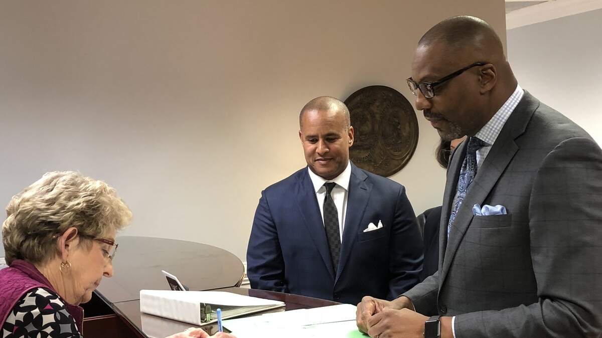 FILE - Columbia lawyer Byron Gipson, with Rep. Todd Rutherford, D-Richland, at his side, pays the $5,640 filing fee Tuesday for the 5th Circuit Solicitor’s position.