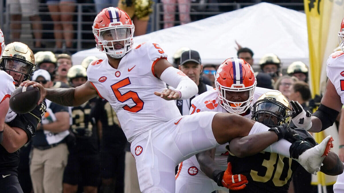 Clemson quarterback DJ Uiagalelei (5) looks to pass as Wake Forest defensive lineman Jasheen Davis (30) tries to tackle him during the second half of an NCAA college football game in Winston-Salem, N.C., Saturday, Sept. 24, 2022. (AP Photo/Chuck Burton)