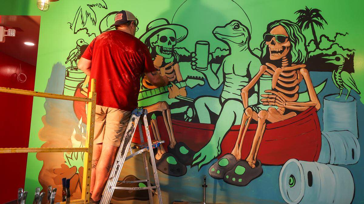 Michael Geddings works on a mural inside Voodoo Brewing Company in Lexington. The restaurant and bar is located on Lexington’s Main Street.