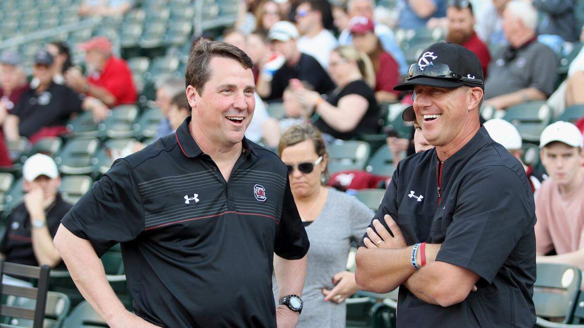 Head coach Mark Kingston, right, talks with the head coach of Football Will Muschamp, who threw the first pitch against the University of North Carolina during the 2018 Collegiate Baseball Series at the BB&T ballpark in Charlotte, N.C. on Tuesday. 4/3/2018.