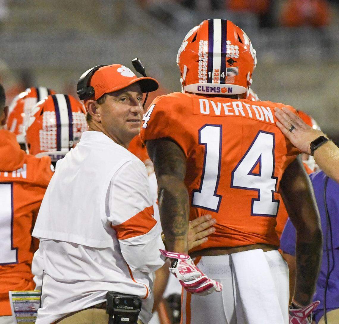 Clemson Head Coach Dabo Swinney looks back after greeting wide receiver Diondre Overton (14) following his third touchdown catch during the fourth quarter at Memorial Stadium before the game with Boston College in Clemson, South Carolina Saturday, October 26, 2019.