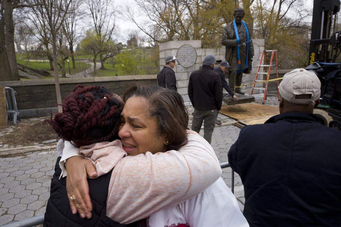 Dr. Bernadith Russell hugs a friend as the statue of Dr. J. Marion Sims is removed from New York's Central Park on Tuesday, April 17, 2018.