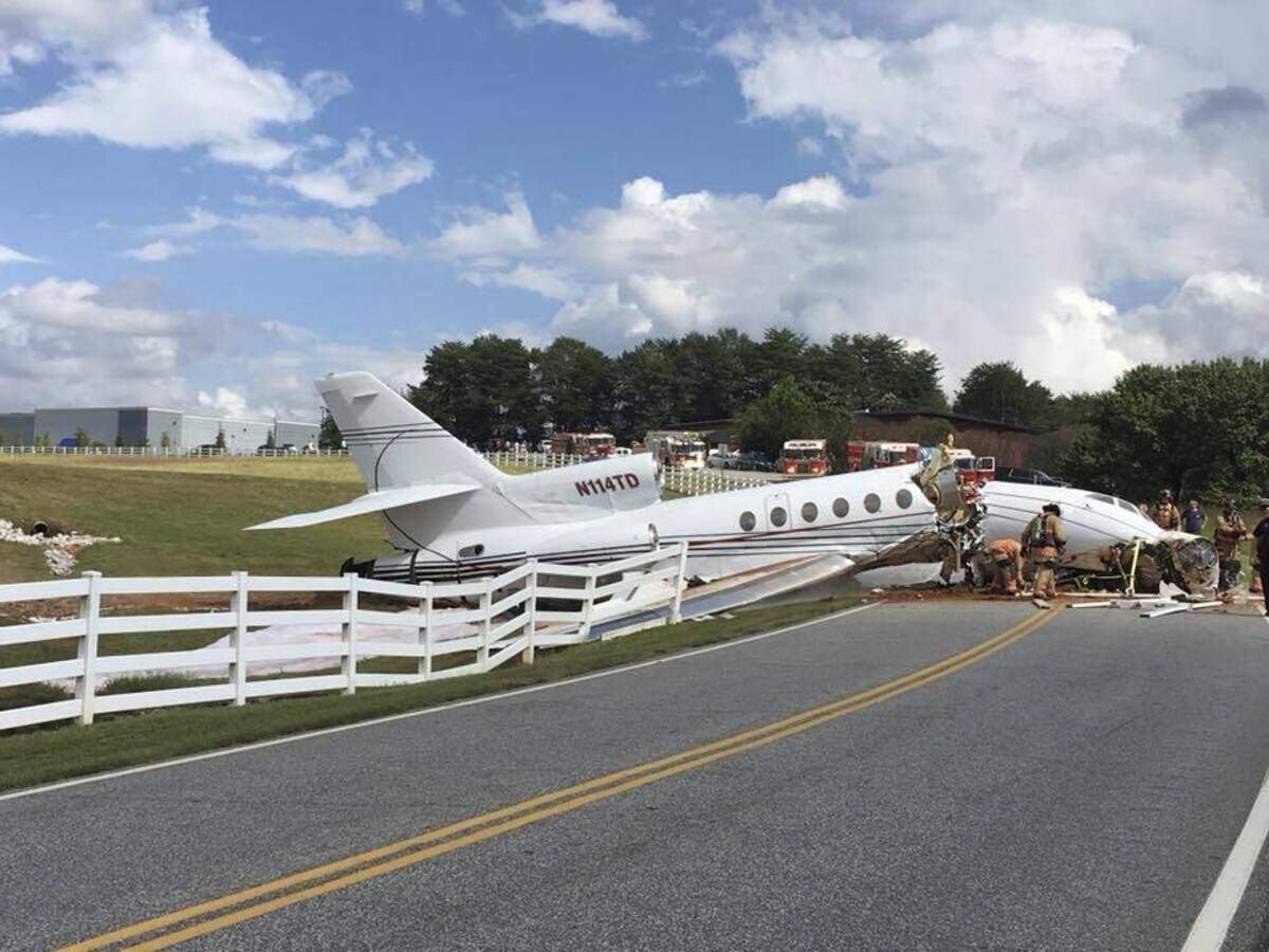 This photo provided by the Greenville, S.C. Police Department shows emergency personnel responding after an aircraft crashed onto Airport Road in Greenville, S.C. Witnesses say the plane appeared to land without a problem until it overshot the runway and went down a steep embankment.