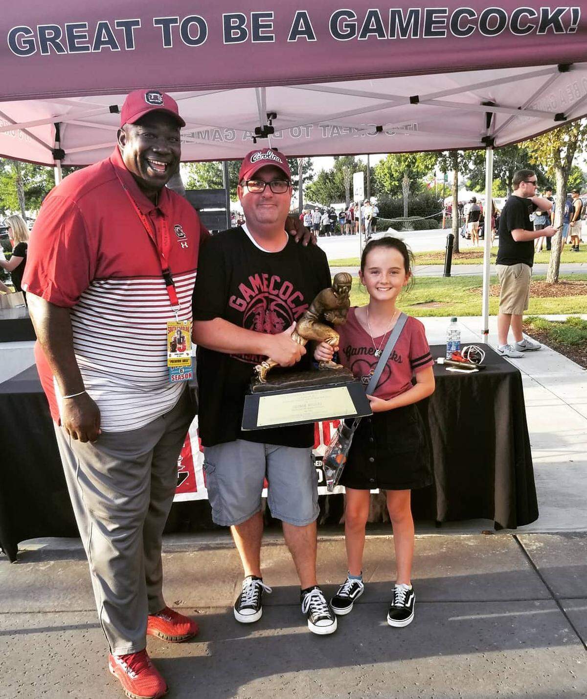 In this 2019 photo, The State’s Chris Trainor, center, and daughter Charley, right, pose with USC alum and Heisman Trophy winner George Rogers before a football game at Williams-Brice Stadium.