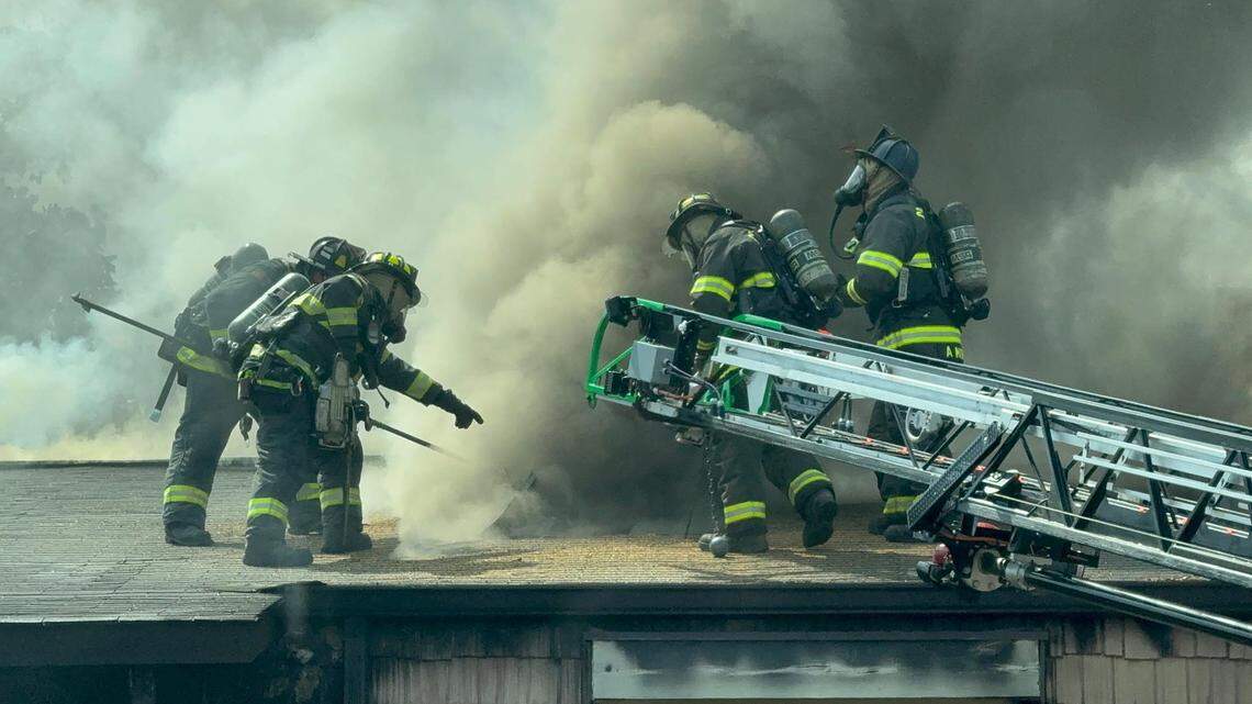 Members of the Irmo Fire District battle a fire from the roof of a condominium.
