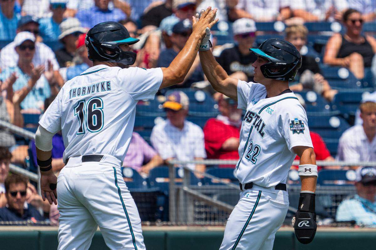 Coastal Carolina Chanticleers first baseman Colby Thorndyke (16) and Coastal Carolina Chanticleers right fielder Blagen Pado (22) celebrate after scoring against the Arizona Wildcats at Charles Schwab Field.