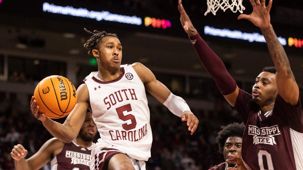 South Carolina Gamecocks guard Meechie Johnson (5) makes a pass under the basket as Mississippi State Bulldogs forward D.J. Jeffries (0) tries to defend at Colonial Life Arena in Columbia on Tuesday, January 31, 2023.