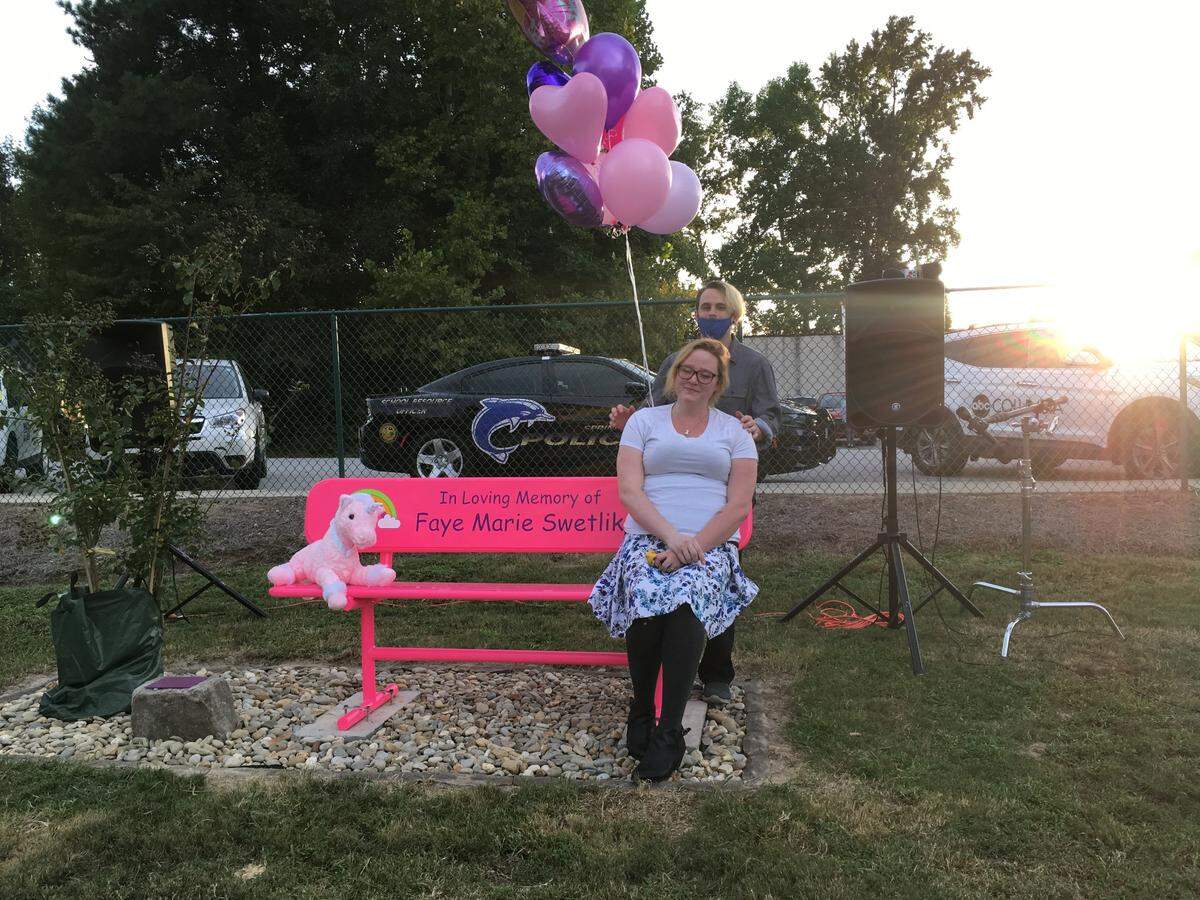 Selena Collins and Chad Swetlik, mother and father of Faye Swetlik, sit on the bench in Springdale dedicated to their slain six-year-old daughter.