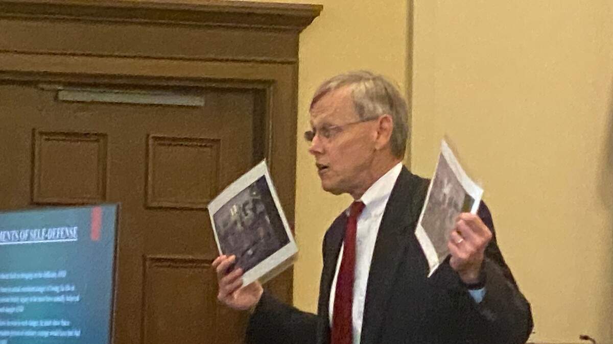 Prosecutor Barney Giese holds up photos of a riot at the Lee Correctional Institution in 2018. Giese prosecuted Michael Smith on charges related to the death of one of the seven inmates killed in the riot.