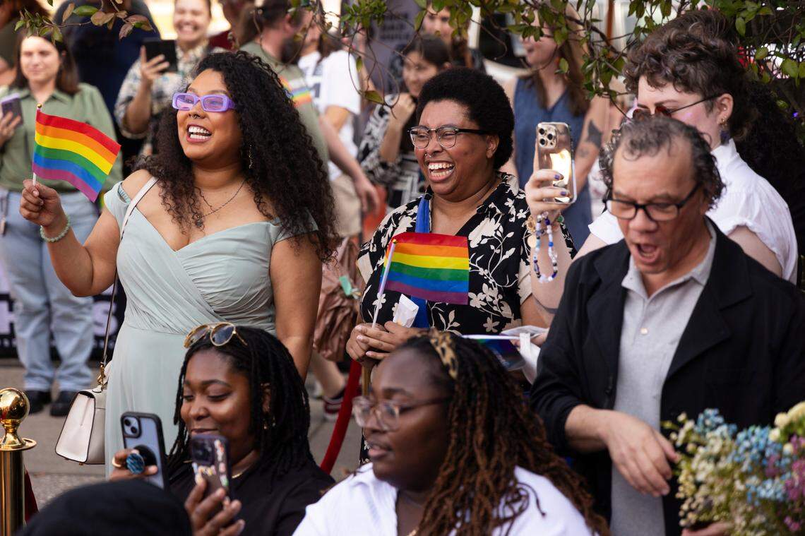 Friends, family and art market attendees watch as Mahkia Greene and Klo Hampton marry at Y’all-Mart, a quarterly art fair series, at Art Bar in Columbia, South Carolina on Sunday, February 9, 2025. Guests of the weddings were given pride flags, and the couples were given free bolo ties, cupcakes, flowers and photography along with the free ceremony.