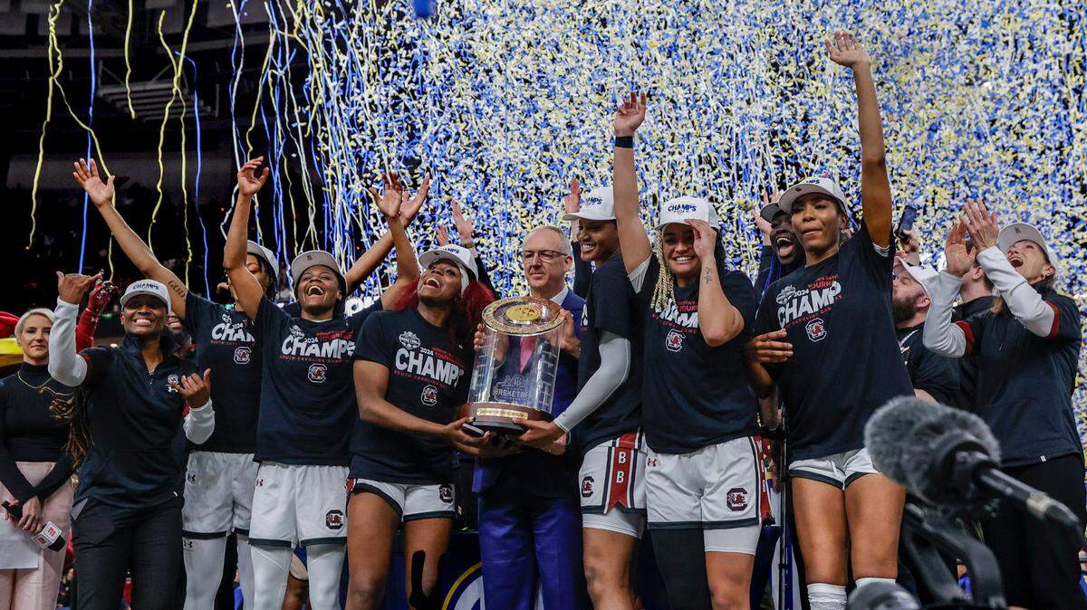 The Gamecocks celebrate with the SEC Tournament trophy after the Gamecocks beat LSU to win the SEC Tournament Championship at Bon Secours Wellness Arena in Greenville on Sunday, Mar. 10, 2024.