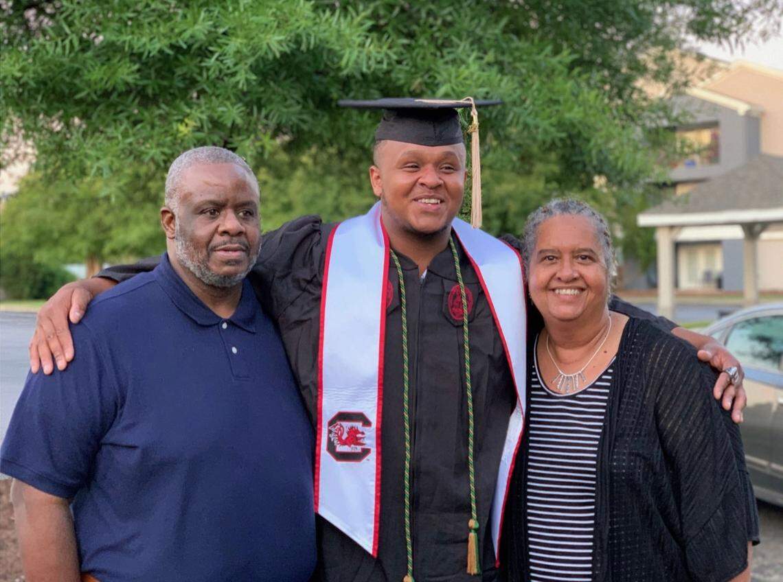 Eric Douglas poses with his parents Eric Sr. and Charlene during graduation in 2021.
