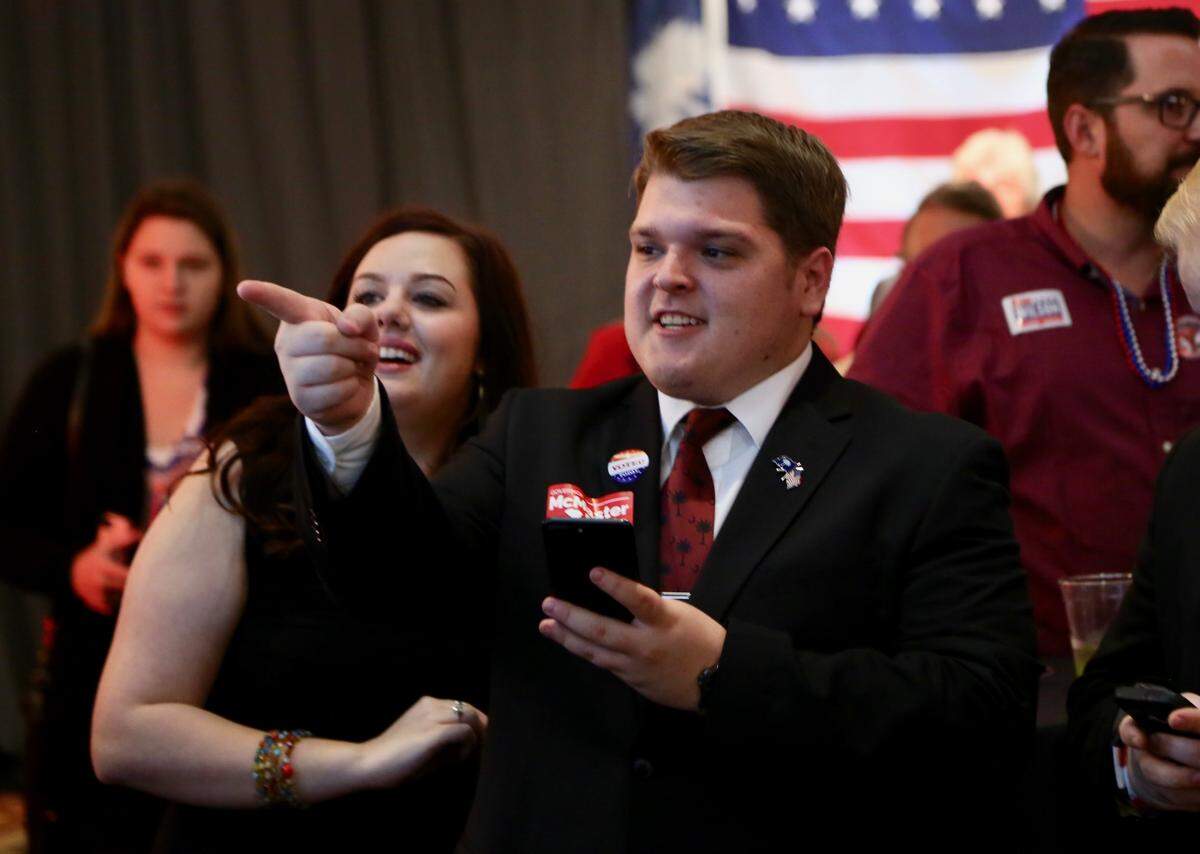 Leah Norman, 21, and Justin Hall, 24, watch returns come in at a McMaster for Governor and S.C. GOP Victory Party in Columbia , S.C., Nov. 6, 2018.