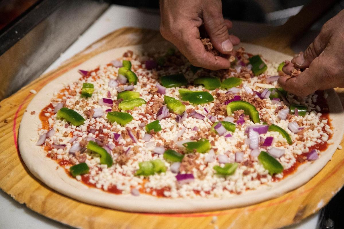 Brian Glynn makes a pizza at Village Idiot in Five Points before testing the oven on Tuesday, September 22, 2020. The restaurant is celebrating 30 years of serving pizza in Five Points while also adapting to the coronavirus.
