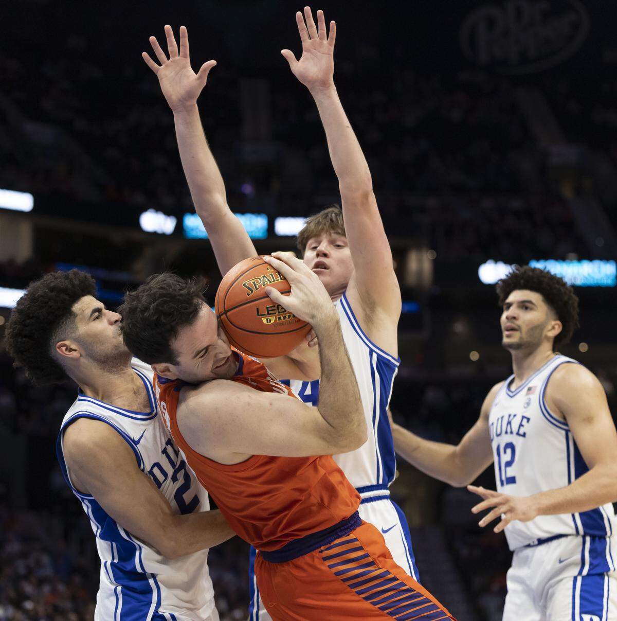 Duke guards Nikolas Khamenia and Cayden Boozer trap Clemson forward Nick Davidson in the second half on Friday, March 13, 2026, during the semifinals of the ACC Tournament at Spectrum Center in Charlotte, N.C