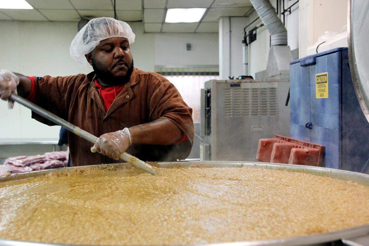 A worker stirs 1,000 pounds of hash at Maurice’s Piggie Park BBQ. Oct. 11, 2023