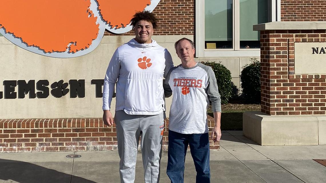 Clemson football offensive lineman Tristan Leigh (left) and fan Brian Darby (right) pose for a photo outside of the team’s Allen N. Reeves Football Complex on Nov. 30, 2023, after a tour.