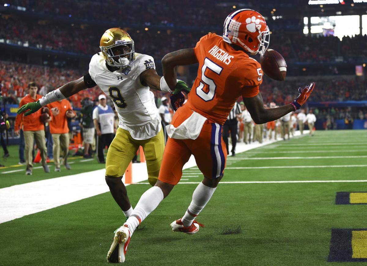 Notre Dame cornerback Donte Vaughn (8) watches as Clemson wide receiver Tee Higgins (5) reaches out to grab a ball tipped by Vaughn for a touchdown in the first half of the NCAA Cotton Bowl semi-final playoff football game, Saturday, Dec. 29, 2018, in Arlington, Texas. (AP Photo/Jeffrey McWhorter)