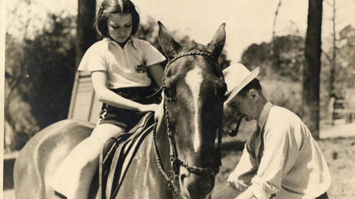 Hughes Webb Sr. helps one of his students get ready for a ride.