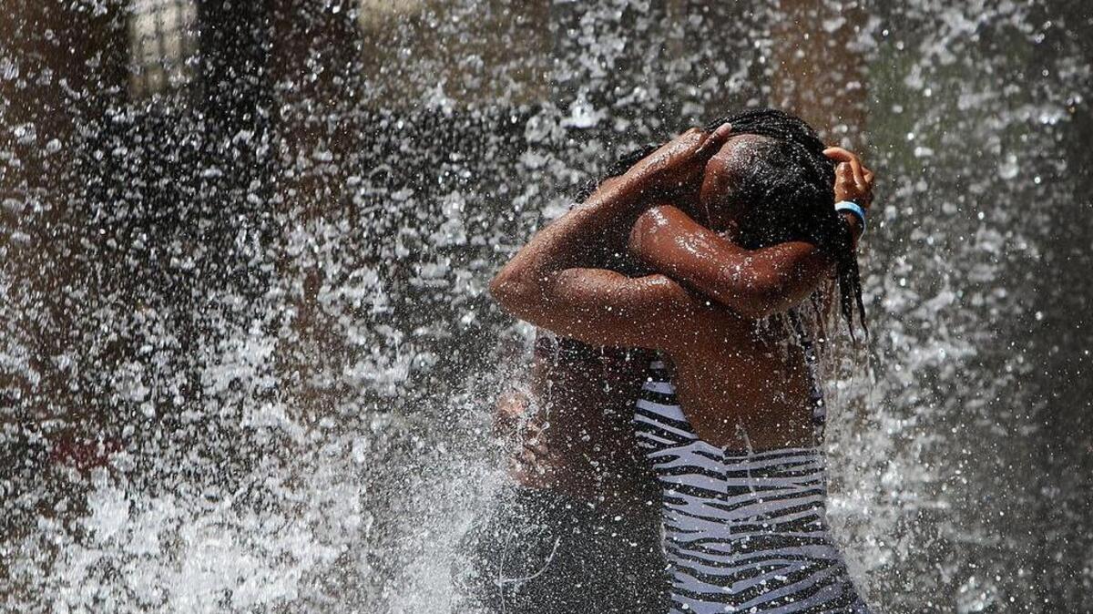(L-R) Sharanda Simmons, 14 and her sister Shida, 25, of Goose Creek, support each other while getting drenched by the open bucket at the Big Splash Tree House at the Whirlin' Waters Adventure Waterpark in North Charleston