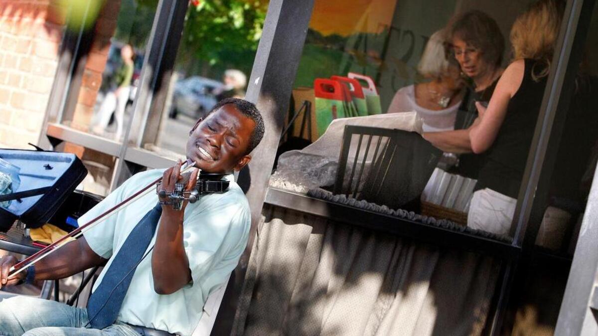 FILE PHOTO 2012: Brian McCollough plays the violin outside Nonnah's on Gervais Street while others peruse art in the window Thursday night during the 21st annual Artista Vista.