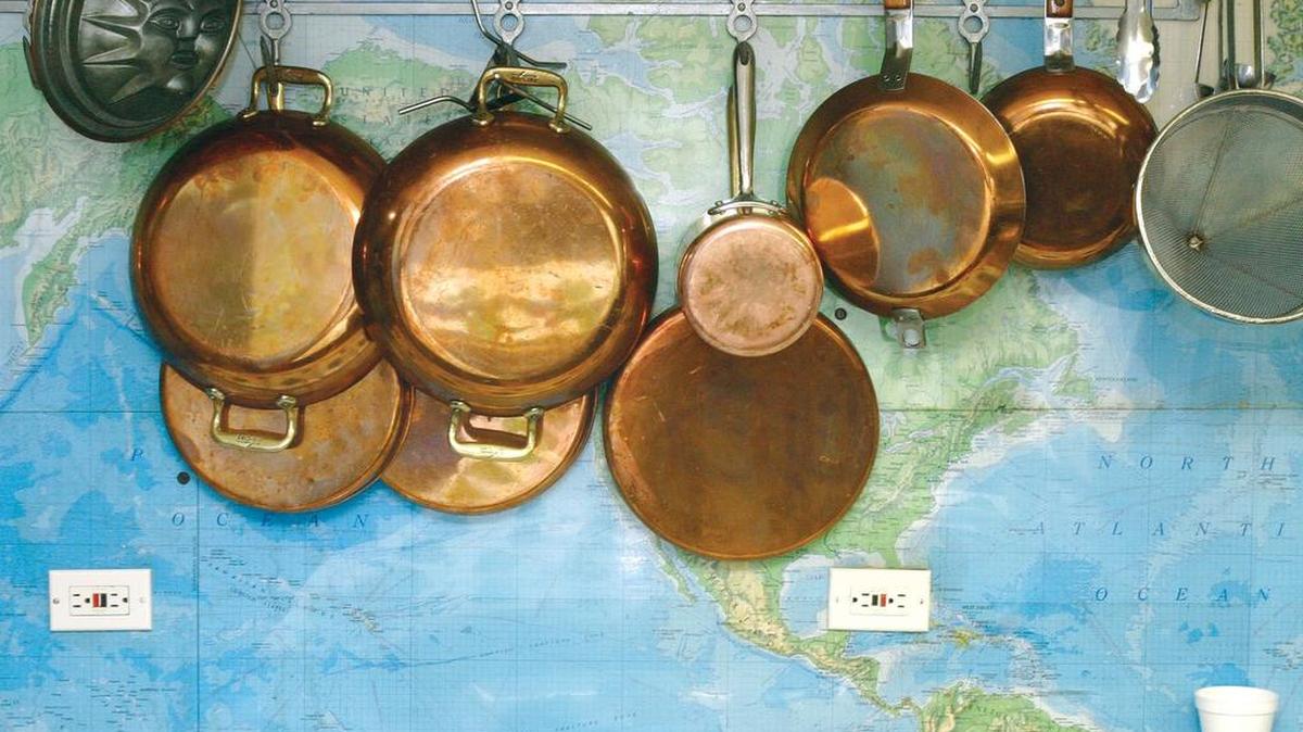 Pots and pans hang along a wall in the kitchen of the James Beard House in New York City.