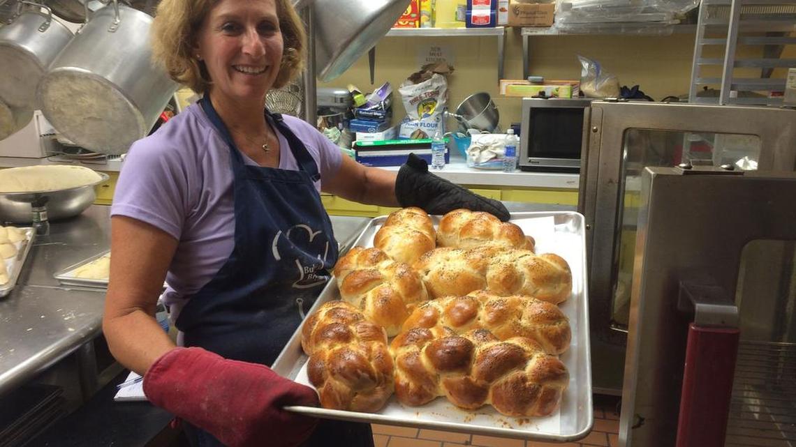 Heidi Lovit shows off a batch of challah, fresh from the oven
