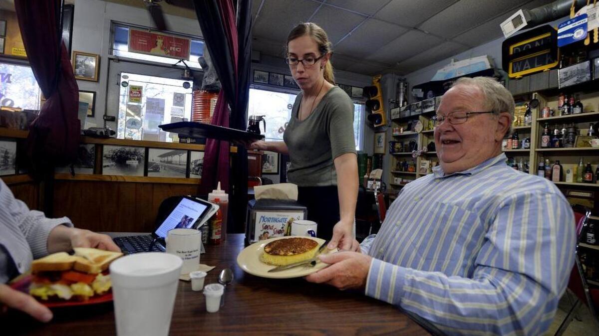Allison Barnett, who has worked at the Northgate Soda Shop for 16 years, places an order in front of Joe Ashley.