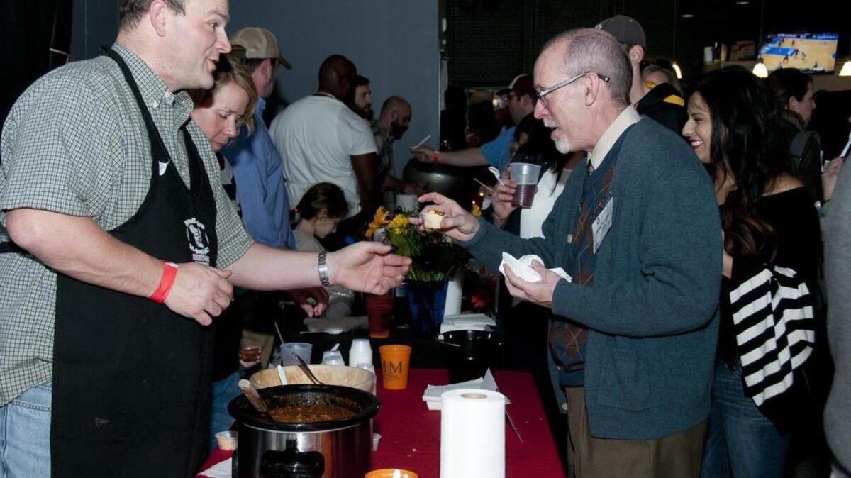 Chili cook-off judge Larry Hembree takes a sample of smoked brisket chili from Jeff Keeney during last year’s Historic Columbia’s Palladium Society’s annual chili cook-off at Music Farm Columbia.