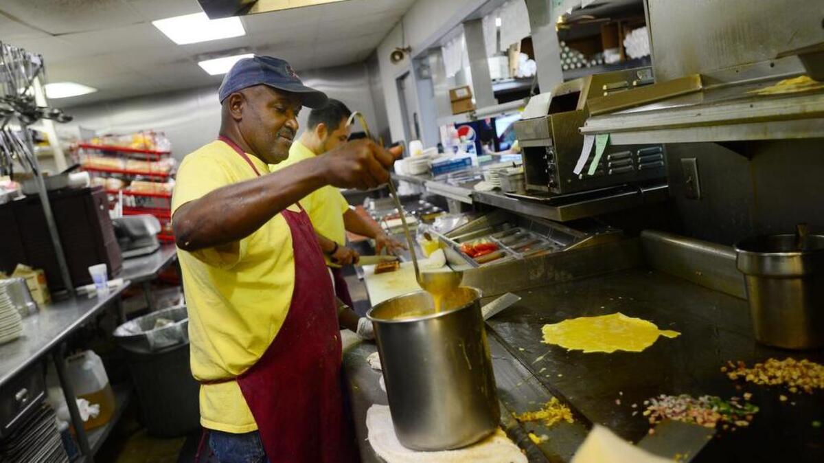 Clyde Green prepares eggs at Tommy’s Ham House in Greenville, a popular stop on the campaign trail.