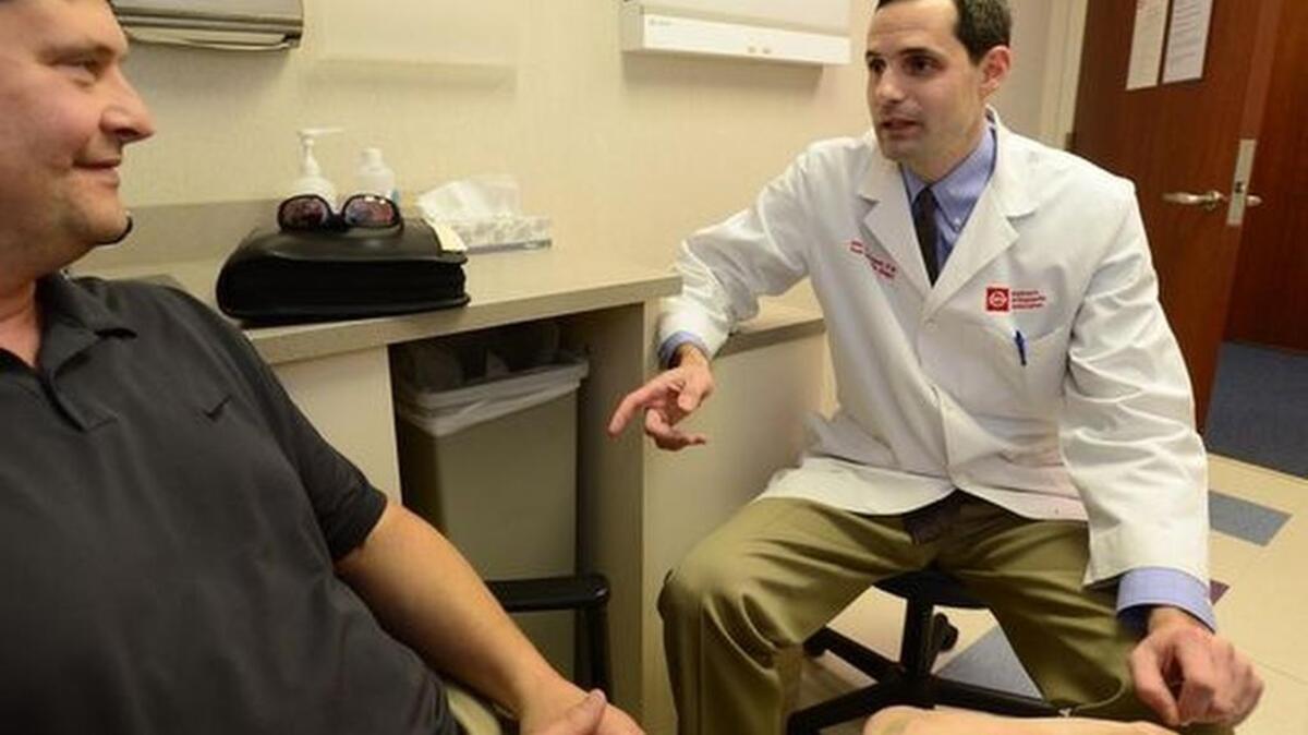 Raymond Bennett, left, meets with Dr. John W. Womack III after his procedure.