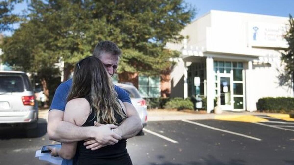 Misty Bridges and Matt Silsbee embrace outside of Animal Emergency Clinic as they get ready to pick up the body of their five-year-old Pomeranian on Monday.