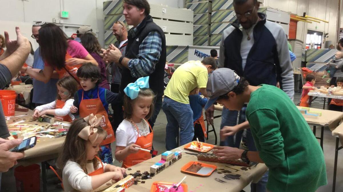 About 80 families gathered at Home Depot Sunday to celebrate the beginning of Hanukkah and make their own Menorahs.