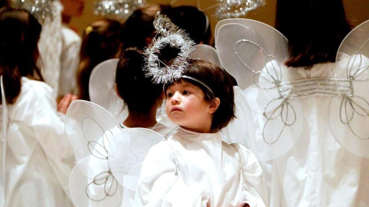 Dressed as an angel, Kimberly Cross, 5, looks at the audience during a Christmas program for the religious education students at St. Joseph Catholic Church.