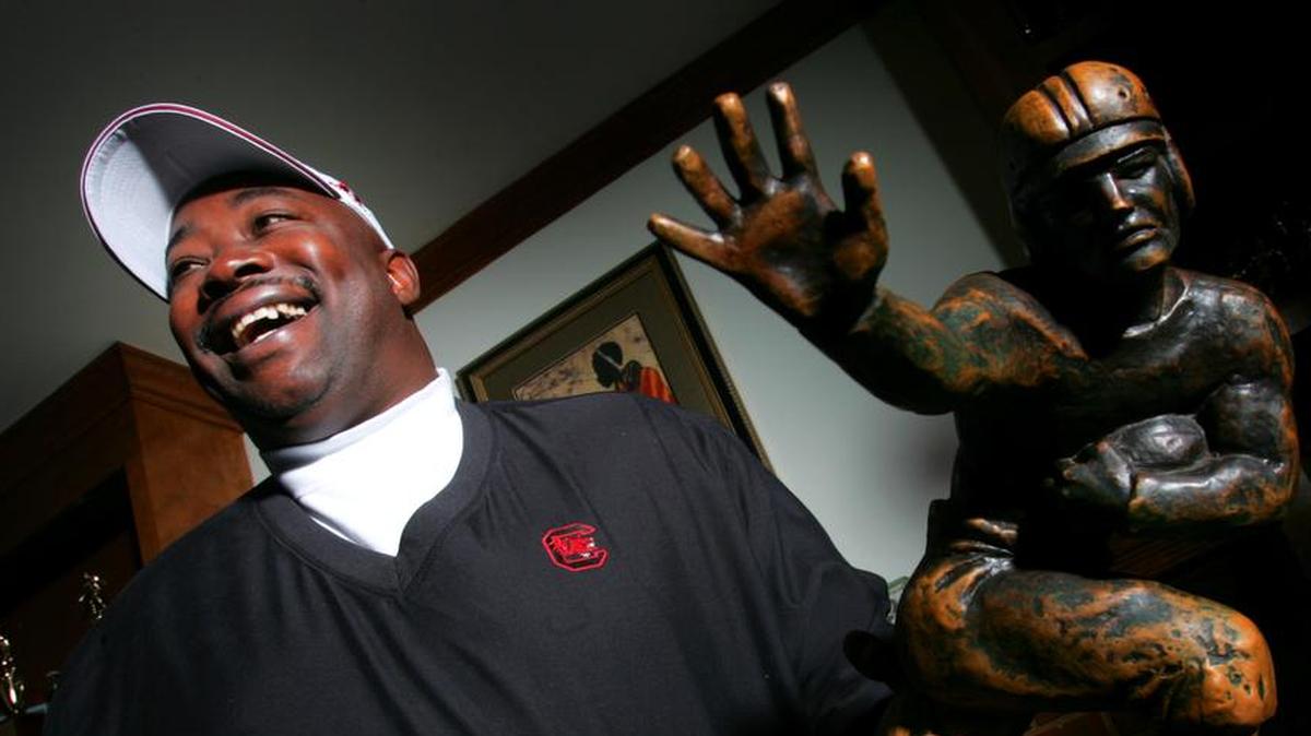 Former USC running back George Rogers with his Heisman trophy