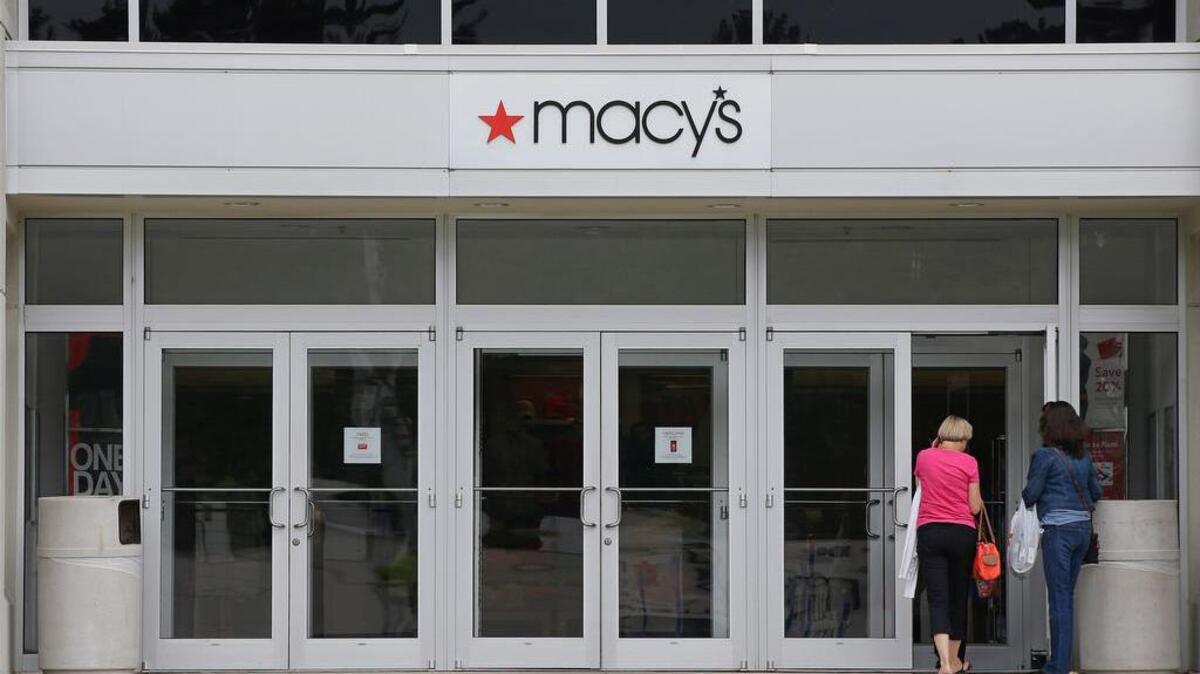 Shoppers walk into a Macy's department store at the Hanover Mall in Hanover, Mass., in July. Macy's is cutting up to about 4,800 jobs after disappointing holiday sales.