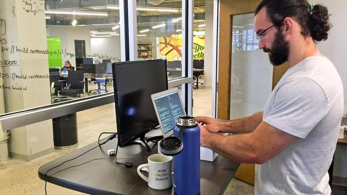 Nick Tate of ContainerShip, a cloud computing company on Pittsburgh’s North Shore, stands about 50 percent of the day. In addition to stretching and working out, he stands at his desk about half of the day to mitigate back pain.