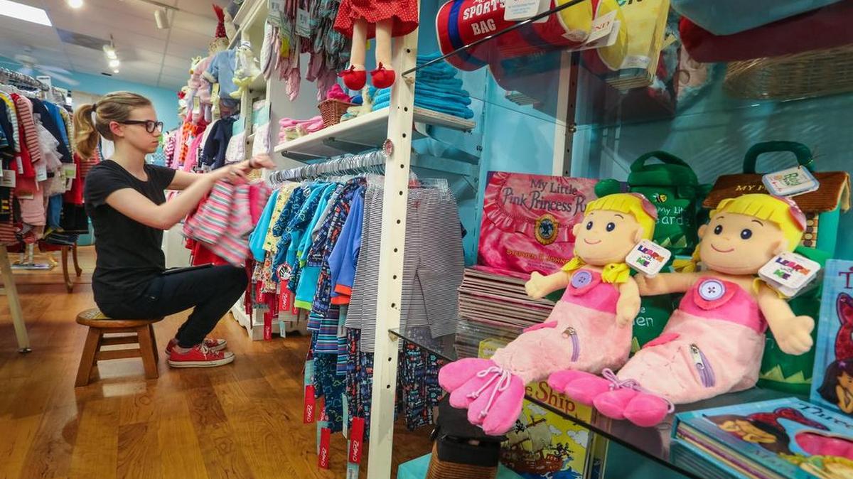 Little Lambs and Ivy's business on Devine Street is rebounding after a lull caused by October's flood in the nearby area. Here, Lydia Davis marks down items for a sale this week.