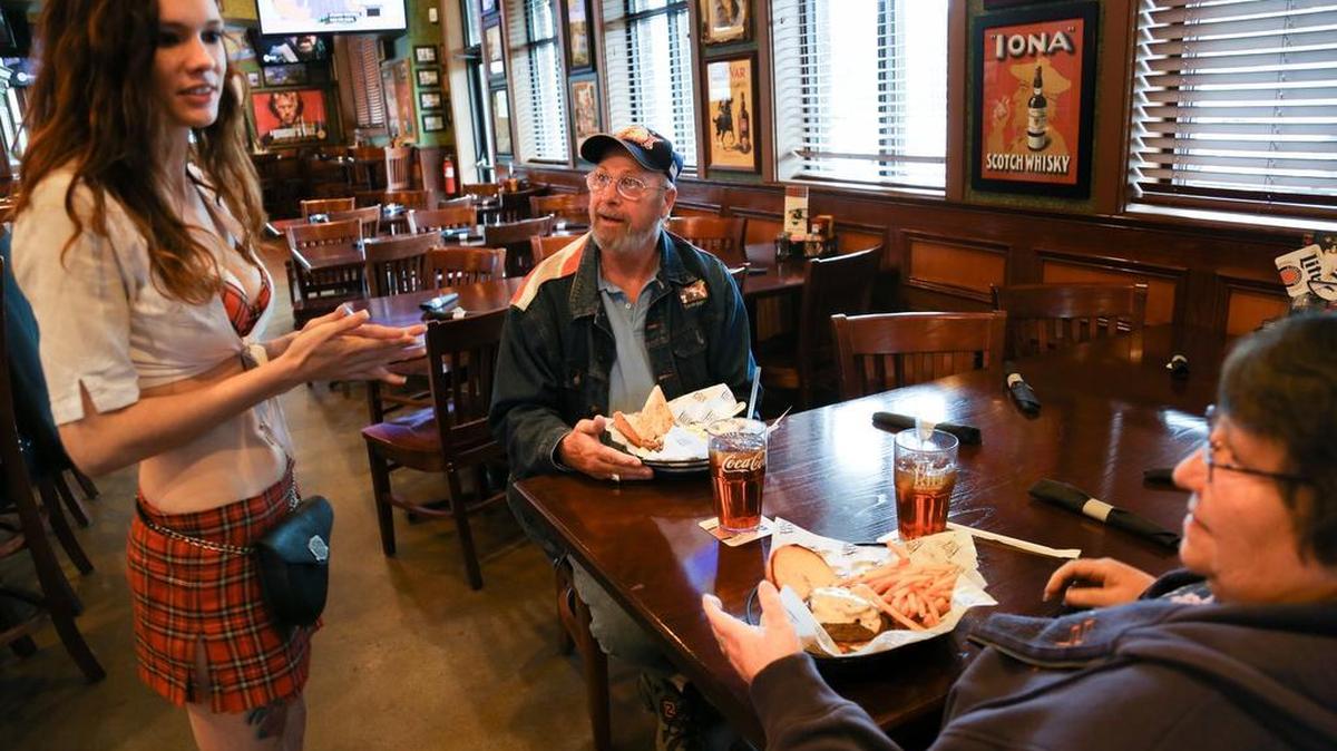 Waitress Claudia White talks with customers, Ron and Linda Van De Weerd at Tilted Kilt in Irmo May 19, 2015.