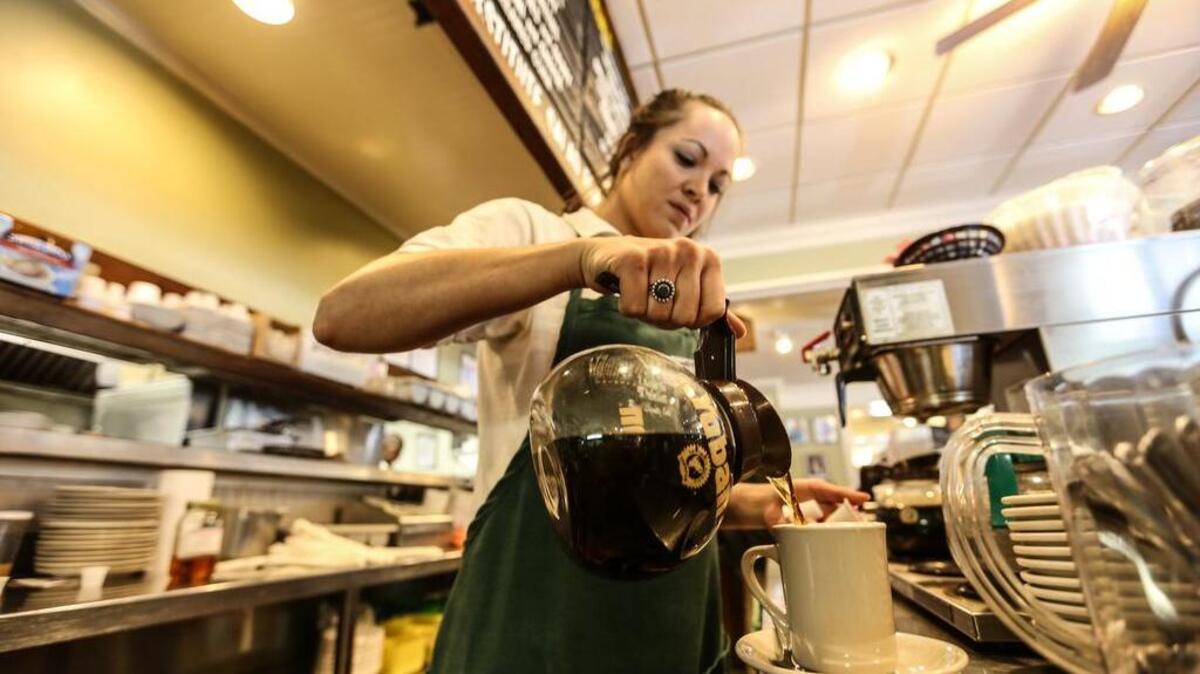 
Lizard's Thicket waitress Carol Anne Cooley pours a cup of coffee Friday, a beverage that was unavailable across Columbia last week because of issues with drinking water related to the flood. 
