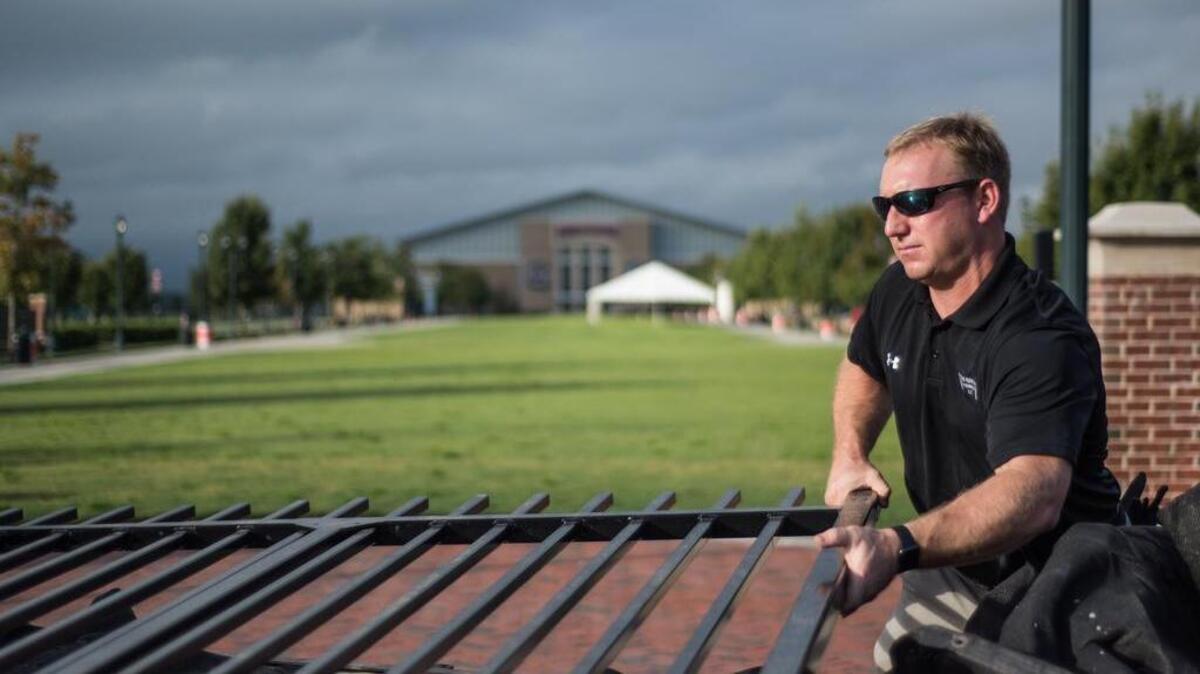 Former Gamecock running back Ryan Brewer installs a new gate to the Tommy Suggs walkway at Gamecock Park on Wednesday across from Williams Brice Stadium. Brewer, the 2001 Outback Bowl MVP operates a fencing company with offices in Columbia and Charleston.