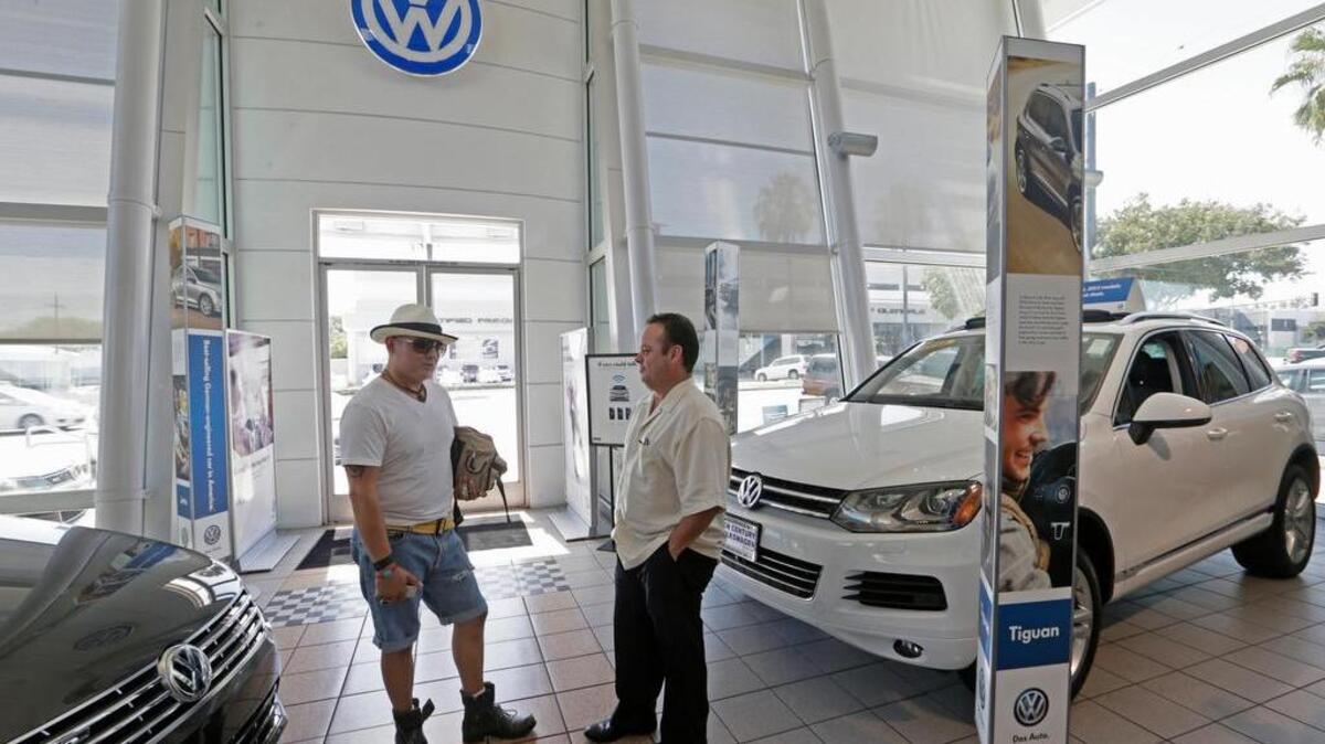 Armando Barillas, left, talks to Sergio Rosas, sales manager at the New Century Volkswagen dealership in Glendale, Calif. For bargain hunters willing to be patient, some car-buying times are better than others. Seasonal fluctuations and carmakers’ redesign schedules can often lead to good deals.
