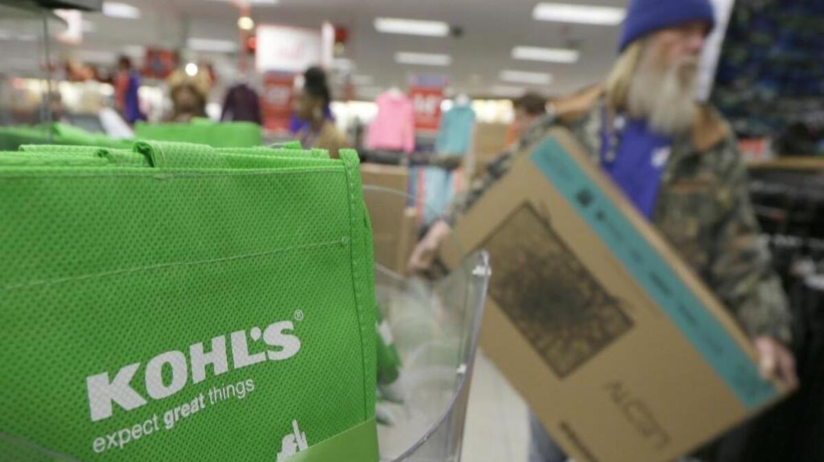 
A customer carries a $99 television from the checkout at a Kohl’s department store in Sherwood, Ark. in this Nov. 27, 2014 file photo. 
