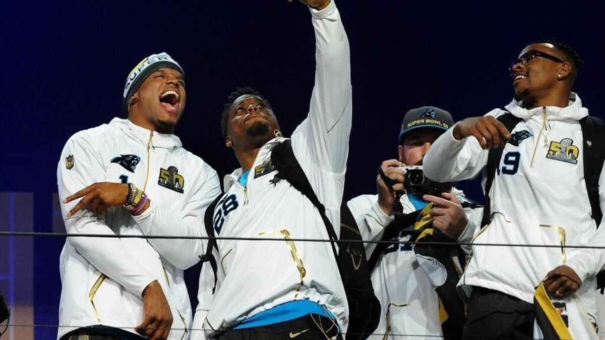 Carolina Panthers quarterback Cam Newton, left and running back Jonathan Stewart, center, joke around while taking a selfie during the Super Bowl Opening Night at SAP Center in San Jose, CA. The Carolina Panthers will face the Denver Broncos in Super Bowl 50 on Feb. 7, 2016 in Santa Clara, CA. At right is wide receiver Ted Ginn, Jr.