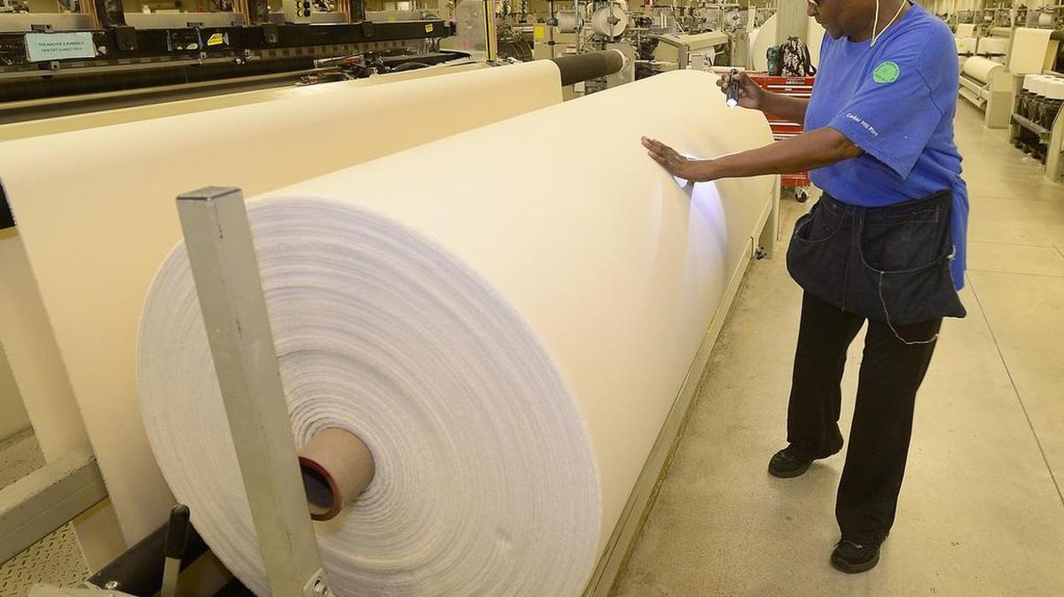 Eva Henderson checks material on the production floor of the Cedar Hill Milliken plant. Milliken and Inman Mills are among the organizations that will be part of the program to produce specialized textiles.