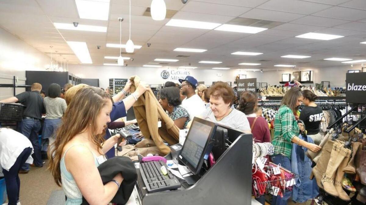 
Owner Alyssa Cox serving customers Friday morning at Clothes Mentor on Cherry Road. 
